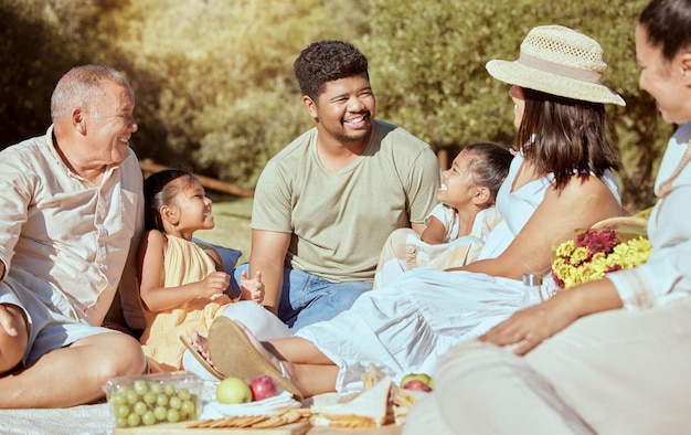 Picnic familiar negro con comida en un parque natural en verano feliz por el tiempo de calidad juntos Felicidad de los padres hijos y ancianos con una sonrisa amor y cuidado al aire libre bajo el sol con los niños