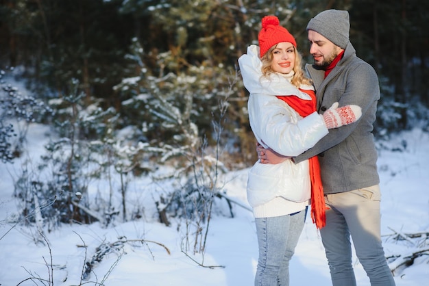 Picnic de invierno en el bosque. Historia de amor en la nieve. pareja en invierno juega en la nieve y abrazándose cerca del pino. Dos amantes en invierno caminan. San Valentín para pareja en estilo rústico. Lovestory de invierno