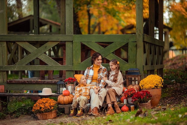 Picnic en la naturaleza en el bosque en otoño. Los niños y la madre de familia feliz pasan tiempo juntos