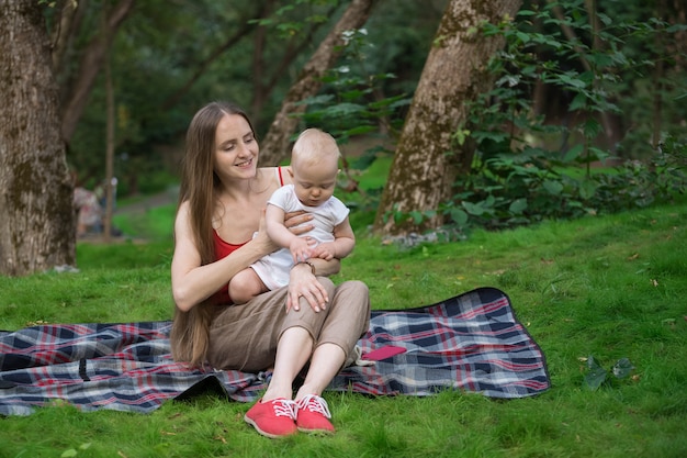 Picnic con niños. Concepto de relajación de unión con niño. Madre y niño sentado manta de picnic.