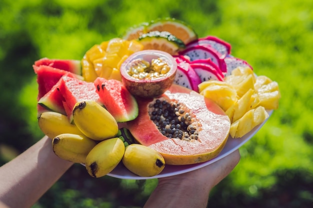 Picnic en el parque on the grass: Un plato de frutas tropicales en el contexto de la hierba.