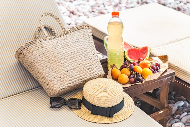 Picnic en la playa frutas frescas en la mesa cerca de las tumbonas