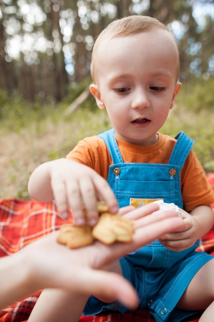 picnic saludable en el bosque. niño feliz comiendo