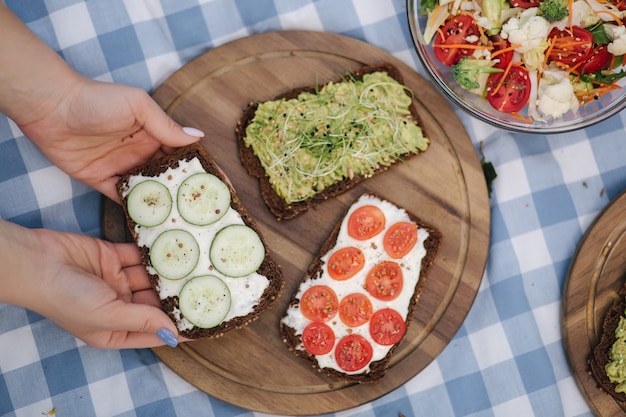 Picnic vegano al aire libre sobre un mantel a cuadros azul