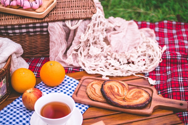 Picnic de verano con una canasta de comida en una manta en el parque.