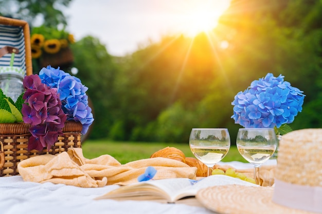 Picnic de verano en un día soleado con pan, fruta, ramo de flores de hortensias