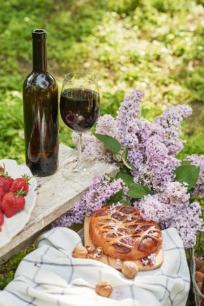 Picnic de verano en el jardín Pastel de vino frutas y flores Bodegón Almuerzo de Pascua y mesa