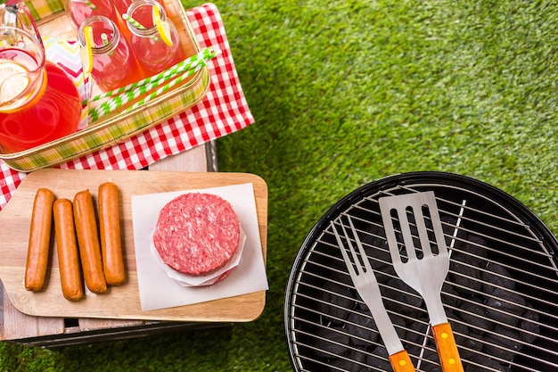 Picnic de verano con una pequeña parrilla de carbón en el parque.