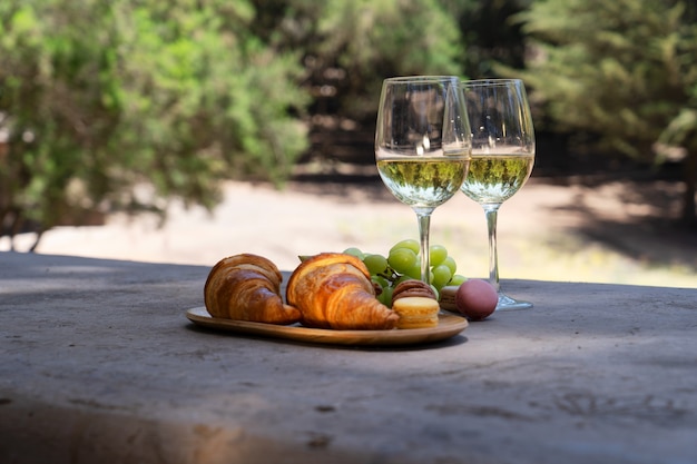 Picnic con vino blanco y croissants en el bosque