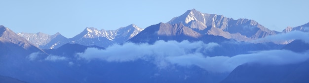 Pico da montanha na neblina matinal e nuvens