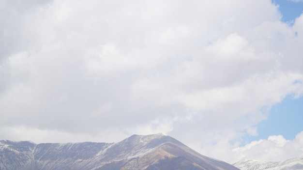 Foto pico de montanha com algumas nuvens e céu azul claro