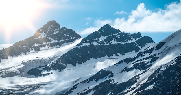 Pico de montaña de montañas cubiertas de nieve hermoso panorama de montañas rocas altas oscuras contra el cielo azul brillante montañismo Imagen panorámica