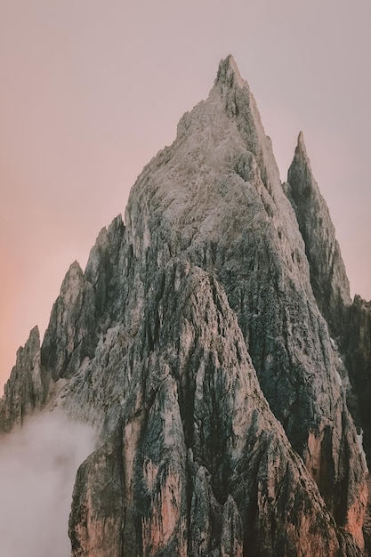 Pico de montaña en las nubes con un cielo rosa