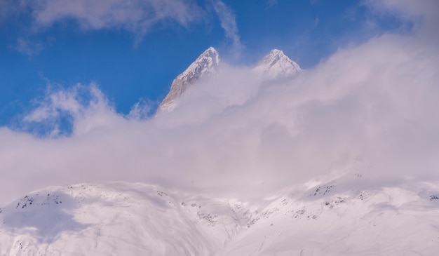 Pico nevado detrás de las nubes