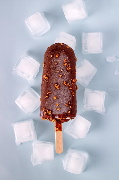 Picolé em cubos de chocolate e gelo em um foco seletivo de fundo azul