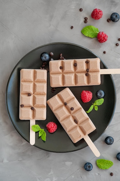 picolés de sorvete de chocolate com framboesa fresca e espaço para cópia de mirtilo Vista superior