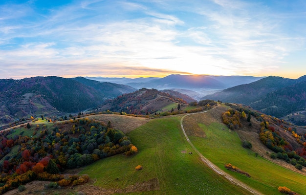 Picos de montanha cobertos de árvores coloridas ao pôr do sol