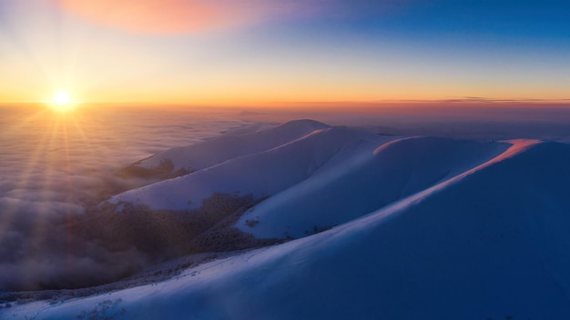 Picos de montanha cobertos de neve ao amanhecer Vista de um drone Carpathian Mountains ucraniano