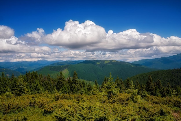 Picos de montanha em nuvens de tempo ensolarado e céu azul