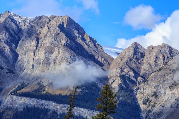 Picos de montanhas envoltos em neblina e nuvens Parque Nacional de Banff, Alberta, Canadá