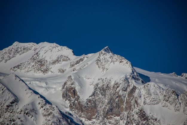 Picos de montanhas nevadas e céu azul claro