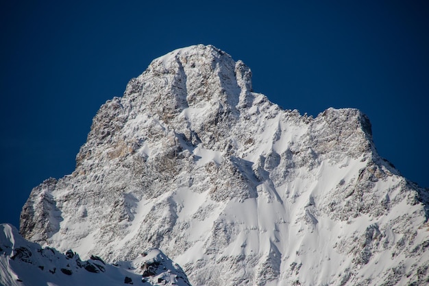 Picos de montanhas nevadas e céu azul claro