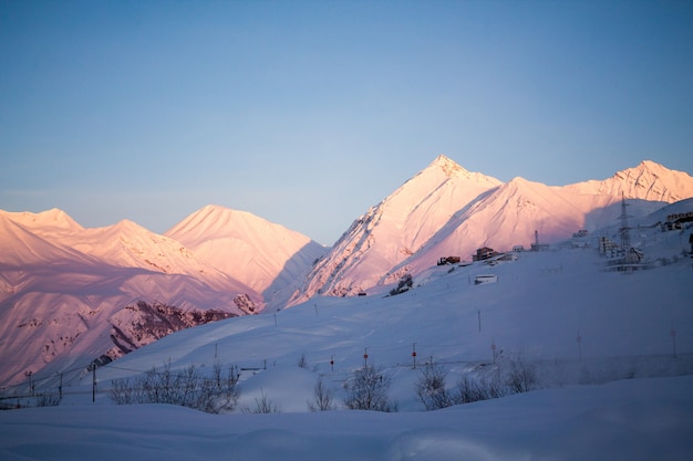 Picos de las montañas del Cáucaso, amanecer del sol. Impresionante vista desde la montaña Kazbek, Georgia. Concepto de motivación de viaje.