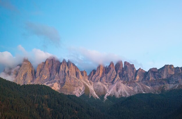 Picos de las montañas Dolomitas cubiertos de nubes en el pueblo de Santa Maddalena al atardecer