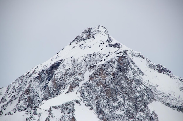 Picos de las montañas nevadas en las nubes cielo azul Cáucaso