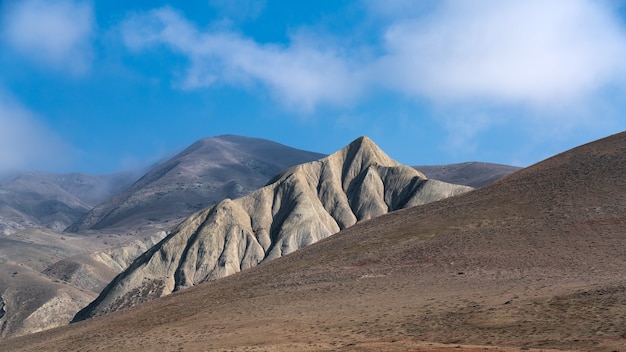 Picos de las montañas con nubes en un cielo azul