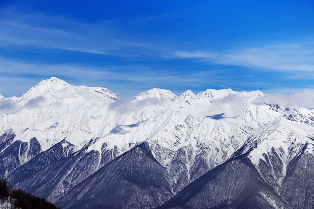 Picos nevados da cordilheira do Cáucaso. Belas vistas da estância de esqui de Rosa Khutorin. Paisagem do inverno com céu azul.