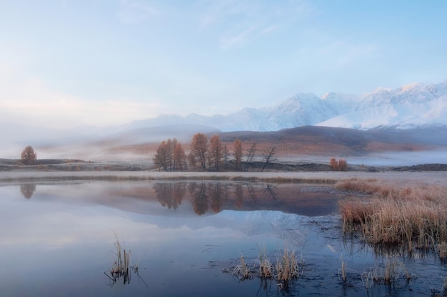 Foto los picos nevados se reflejan en el agua fría y tranquila de una montaña.