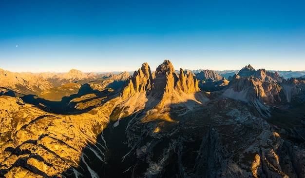 Foto picos rocosos de tre cime di lavaredo al amanecer paisaje montañoso de amplios cañones montañosos y valles