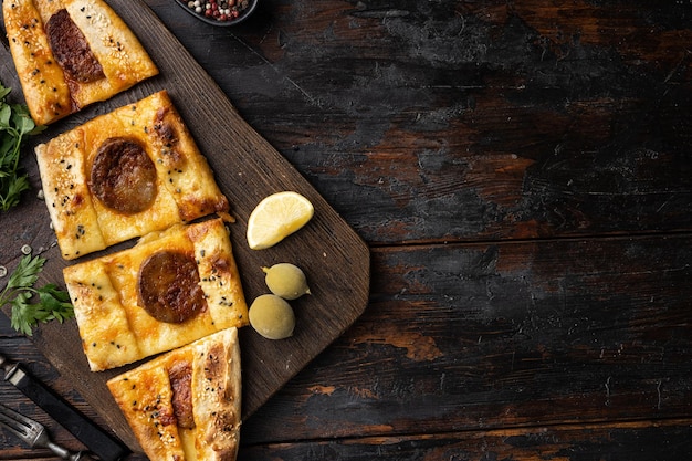 Foto pide de linguiça turca ou pizza de linguiça no fundo da velha mesa de madeira escura vista superior plana com espaço de cópia para texto