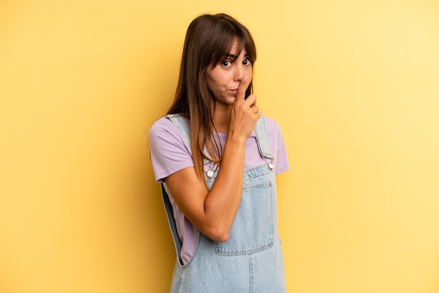 pidiendo silencio y gesticulando silenciosamente con el dedo delante de la boca diciendo shh o manteniendo un secreto