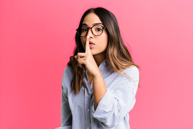 Foto pidiendo silencio y gesticulando silenciosamente con el dedo delante de la boca diciendo shh o manteniendo un secreto