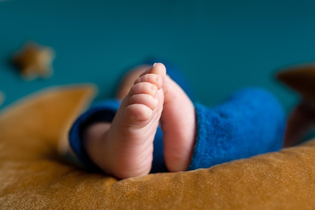 El pie de un bebé está vestido de azul y blanco.