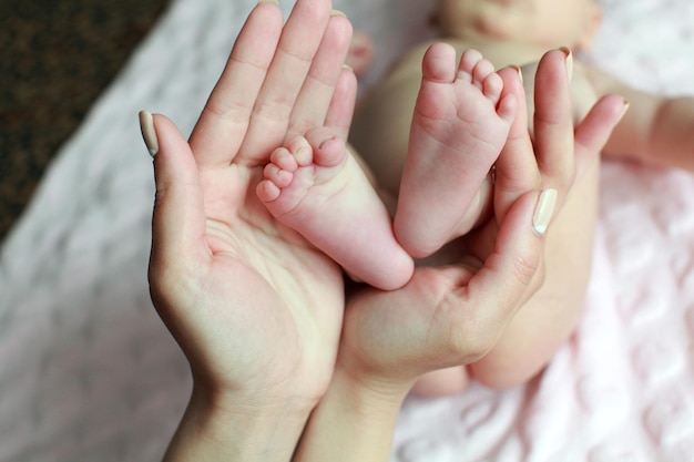 Pie de bebé en manos de la madre con cuidado