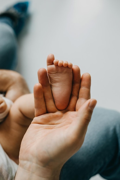 Pie de bebé pequeño en la palma del padre