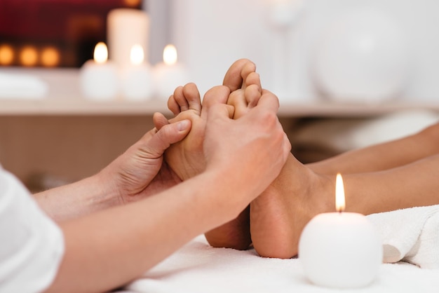 Pie femenino limpio perfecto Hermosa y elegante mano de niña arreglada toca sus pies Exfoliante de spa y cuidado de piernas