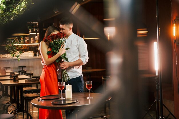 De pie con flores Una pareja romántica cena en el restaurante