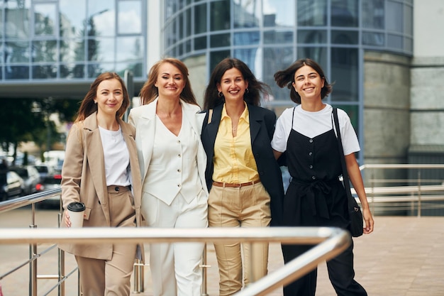 Foto de pie junto a las mujeres en ropa formal está al aire libre en la ciudad