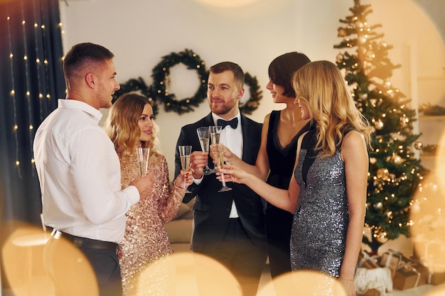 Foto de pie juntos grupo de personas tienen una fiesta de año nuevo en el interior juntos