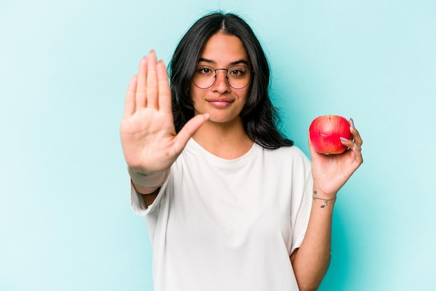 De pie con la mano extendida que muestra la señal de alto que le impide