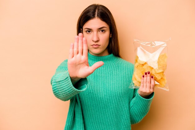 De pie con la mano extendida que muestra la señal de alto que le impide