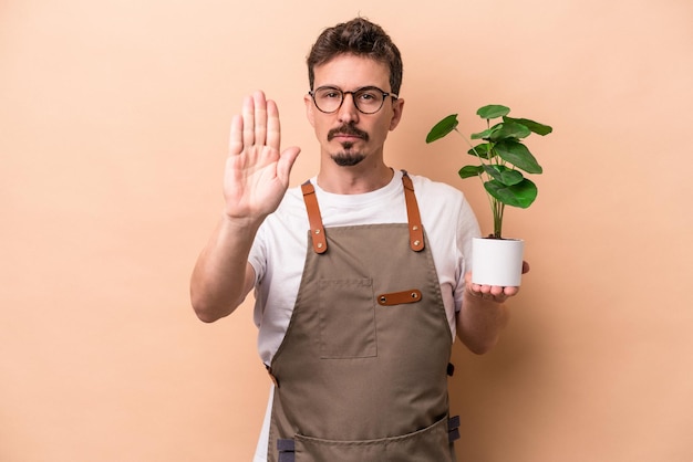 De pie con la mano extendida que muestra la señal de alto que le impide