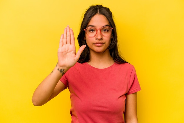 De pie con la mano extendida que muestra la señal de alto que le impide