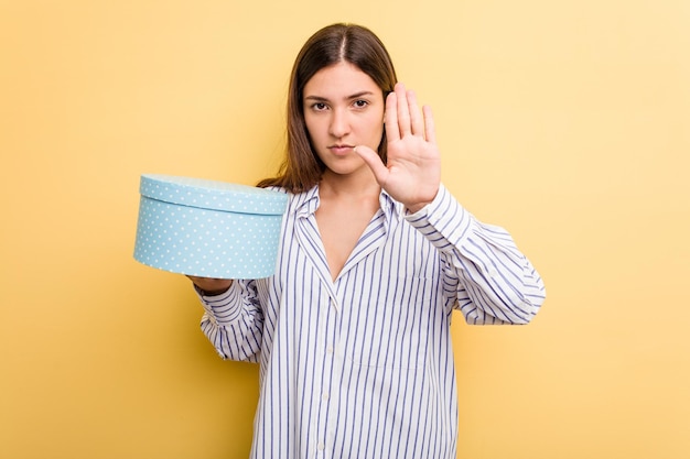 De pie con la mano extendida que muestra la señal de alto que le impide