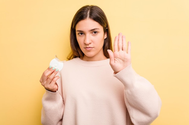 De pie con la mano extendida que muestra la señal de alto que le impide