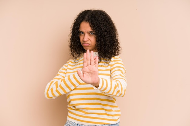 De pie con la mano extendida que muestra la señal de alto que le impide